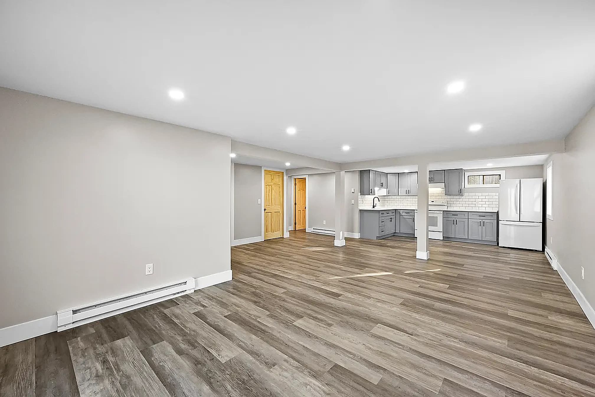 Finished basement with smooth drywall, recessed lighting and new floors