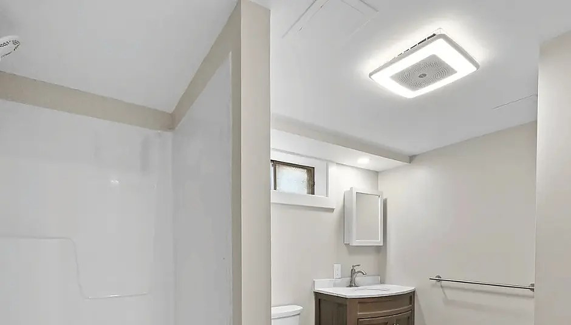 Remodeled bathroom with a new shower surround, vanity and ceiling fan light