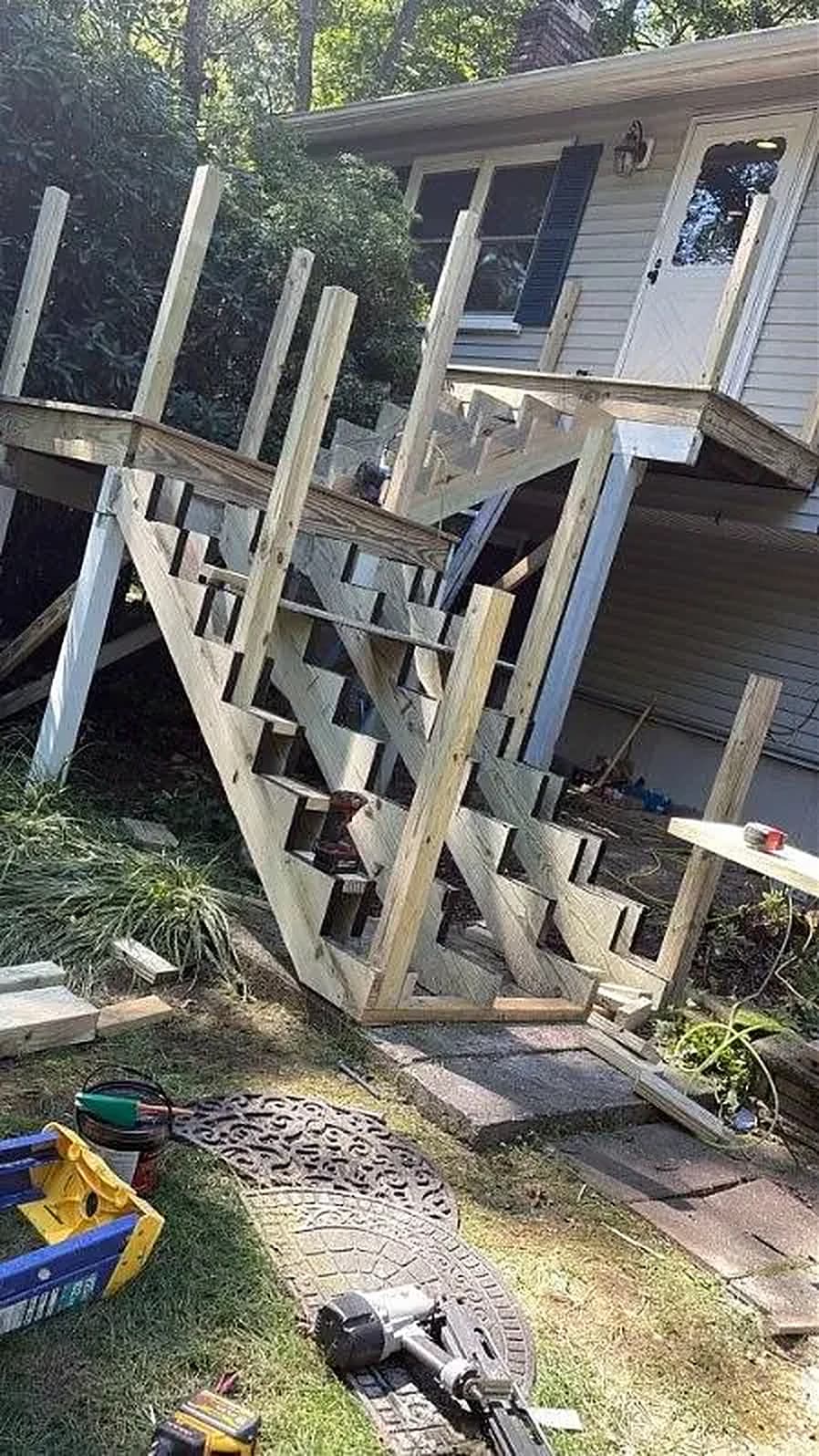 Elevated deck framing and stair stringers against a house