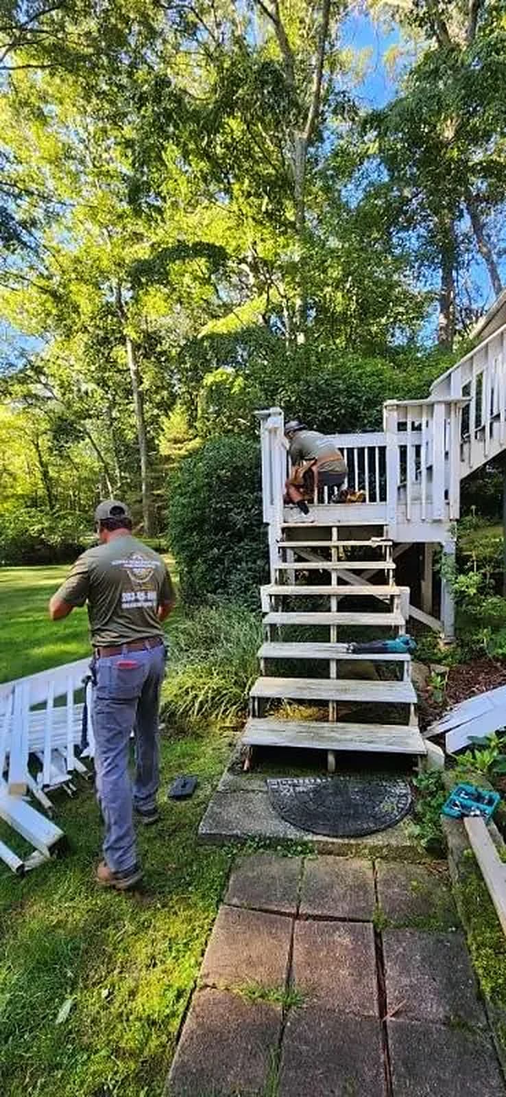 New exterior stairs with white railing leading to a raised deck